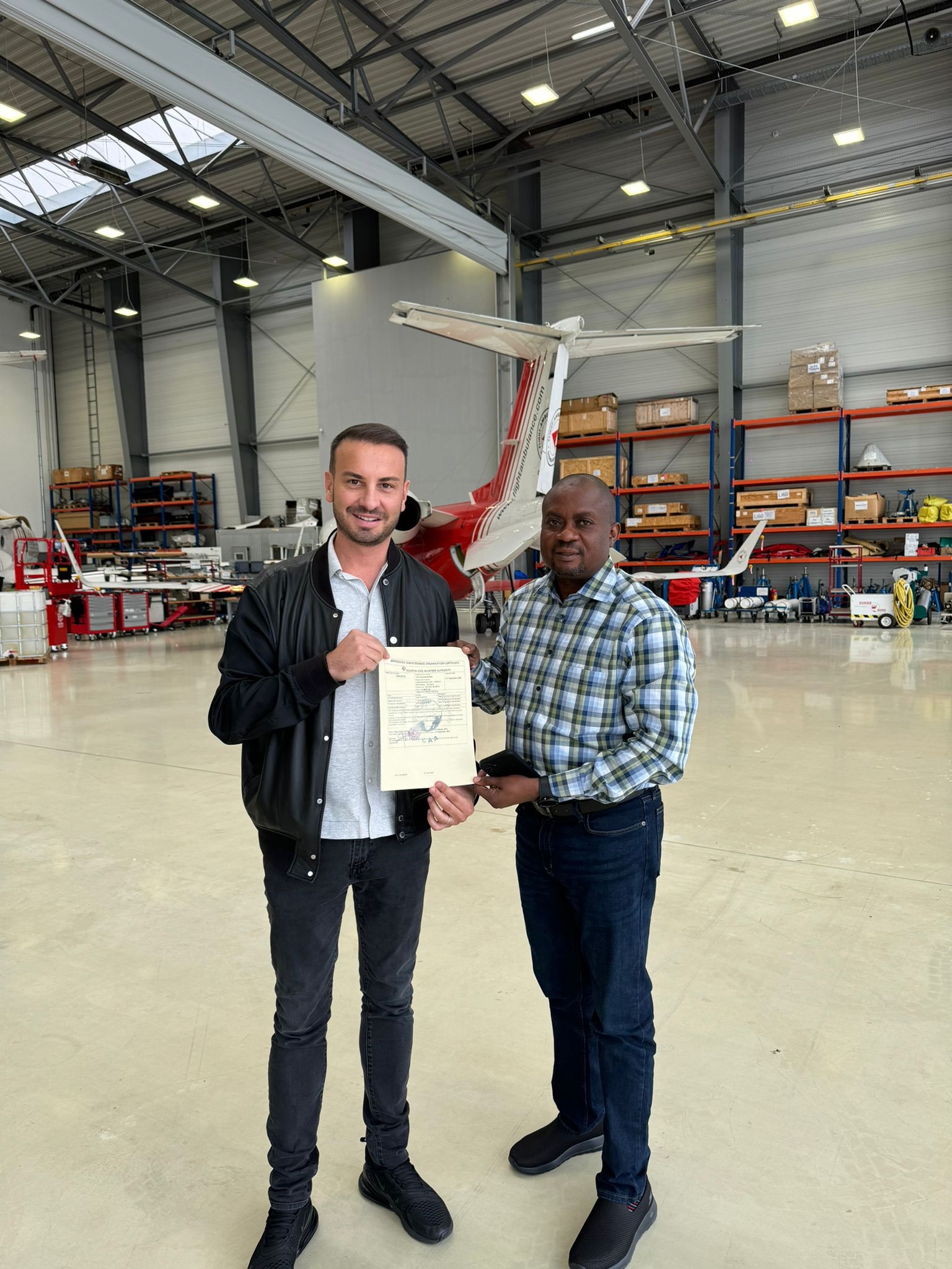 Michael Axtmann (l) receives the AMO certificate from Toks Fadairo (r)