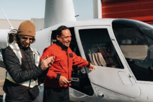 Mikael Cardinal, left, and test pilot Ric Webb, right, of Unither Bioélectronique celebrate after the company’s successful first test flight of a hydrogen-powered Robinson R-44 Raven II helicopter