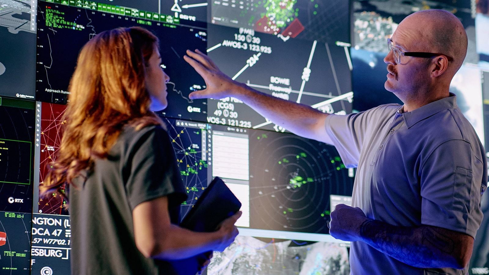 Controllers interact with advanced airspace surveillance and automation displays at a Collins Aerospace facility, supported by radar systems