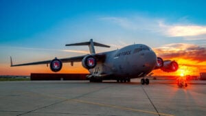 A C-17 sits on the tarmac at sunset