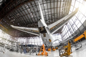 Large passenger aircraft on service in an aviation hangar rear view of the tail, on the auxiliary power unitand tail altitude control, elevating rudder