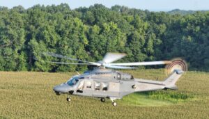 An MH-139A Grey Wolf flies over fields